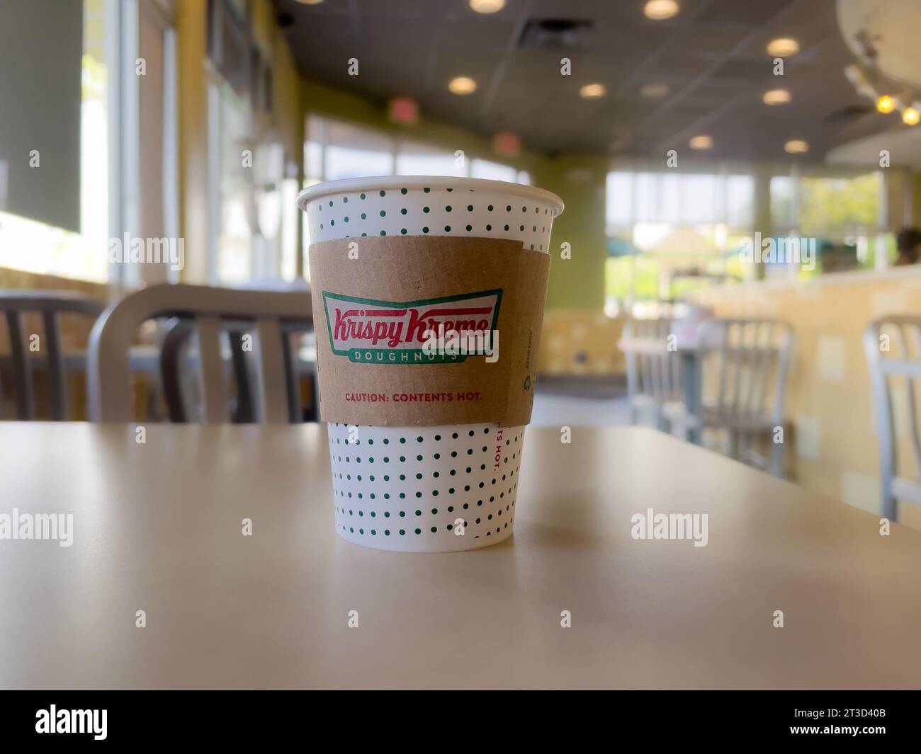 Orange, CA, USA - 23 octobre 2023 : une tasse à café Krispy Kreme en papier avec une manche sur un dessus de table. Banque D'Images