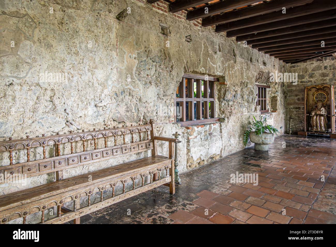 Guatemala, la Antigua - 20 juillet 2023 : Musée Casa Santa Domingo. Long couloir ouvert d'un côté avec sculpture Padre Eterno à la fin Mur ruineux et long Banque D'Images