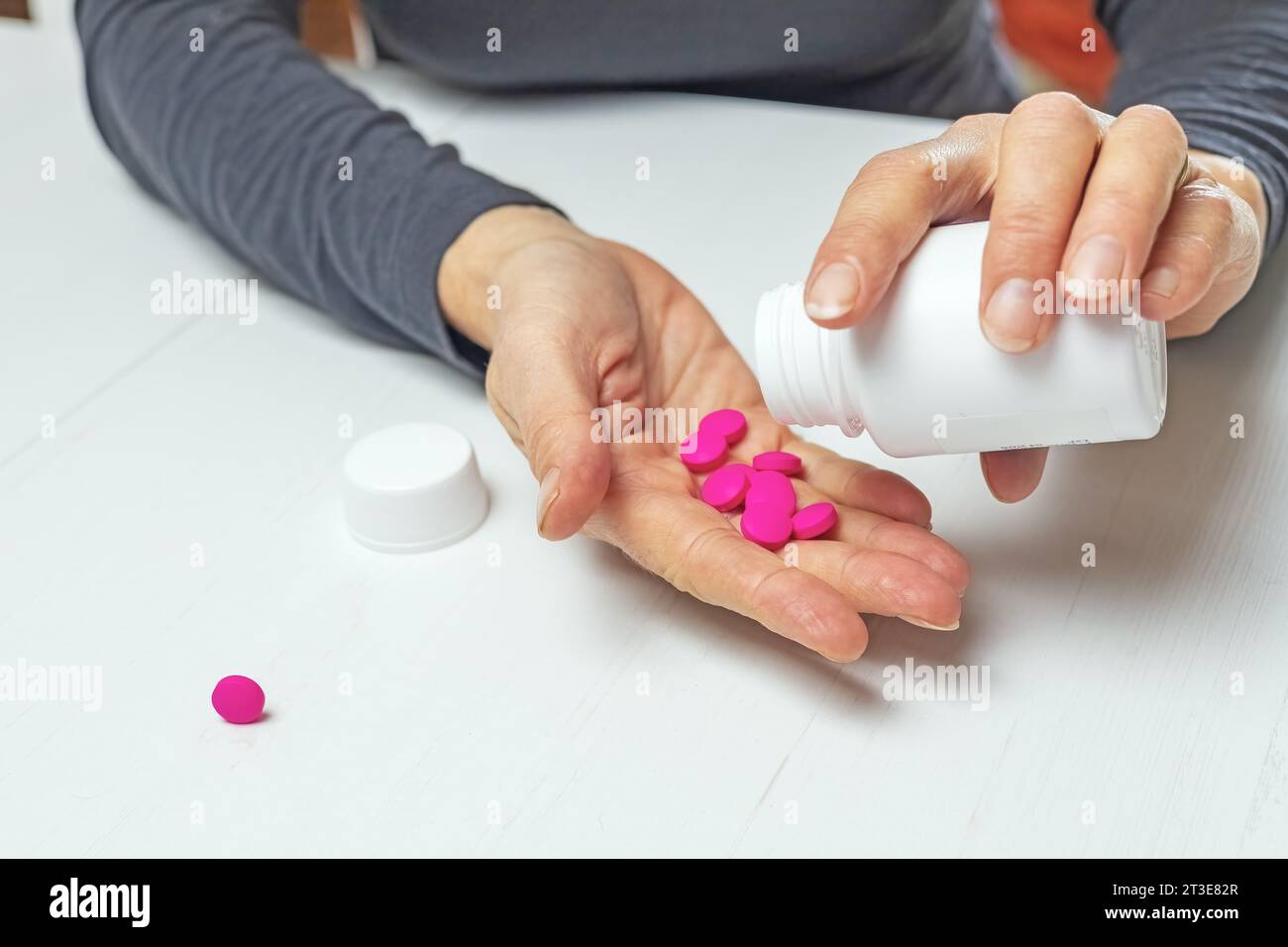 Santé et concept médical. La femme verse des médicaments dans sa main. Banque D'Images