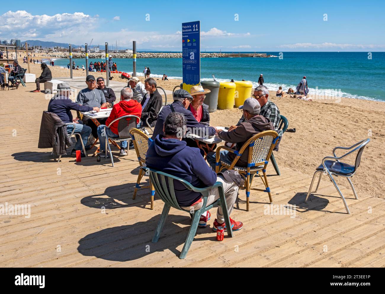 Groupe d'hommes jouent aux dominos sur la plage de la Barceloneta, Barcelone, Espagne Banque D'Images