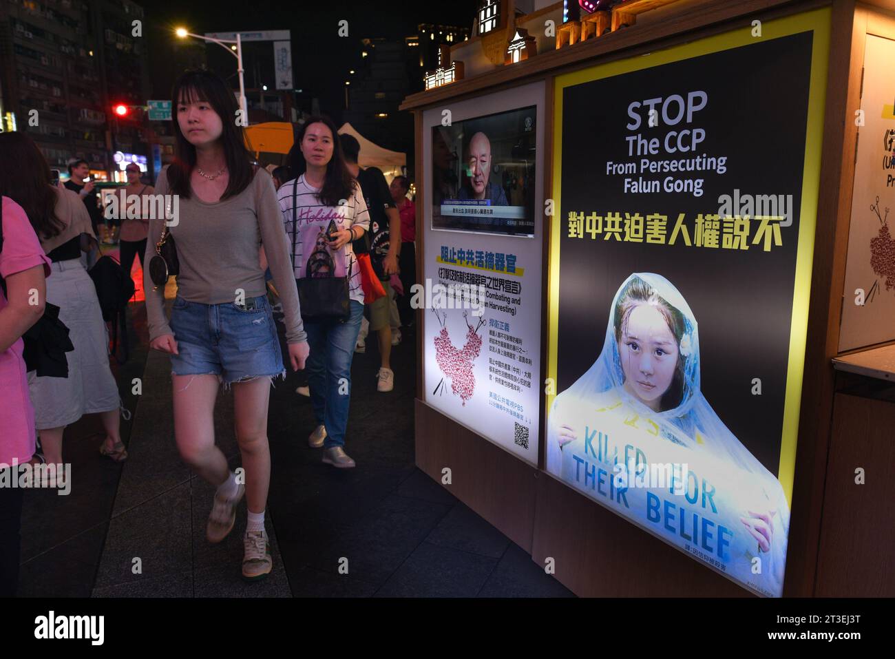 ** STRICTEMENT AUCUNE VENTE AUX MÉDIAS OU ÉDITEURS FRANÇAIS - DROITS RÉSERVÉS ***01 octobre 2023 - Taipei, Taiwan : des jeunes taïwanais sortent dans le quartier de Ximending, marchent devant les panneaux d'affichage du Falun Gong dénonçant les crimes du Parti communiste chinois contre le groupe. Banque D'Images