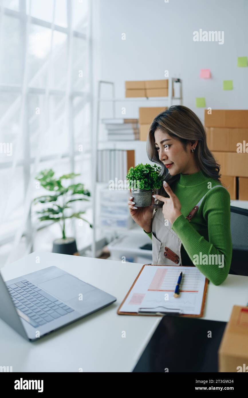Belle femme asiatique, blogueur, blog, présentation de la qualité du produit, vidéo en direct, médias sociaux, l'enregistrer, vendre en ligne via des appareils photo numériques, pme ou petite Banque D'Images