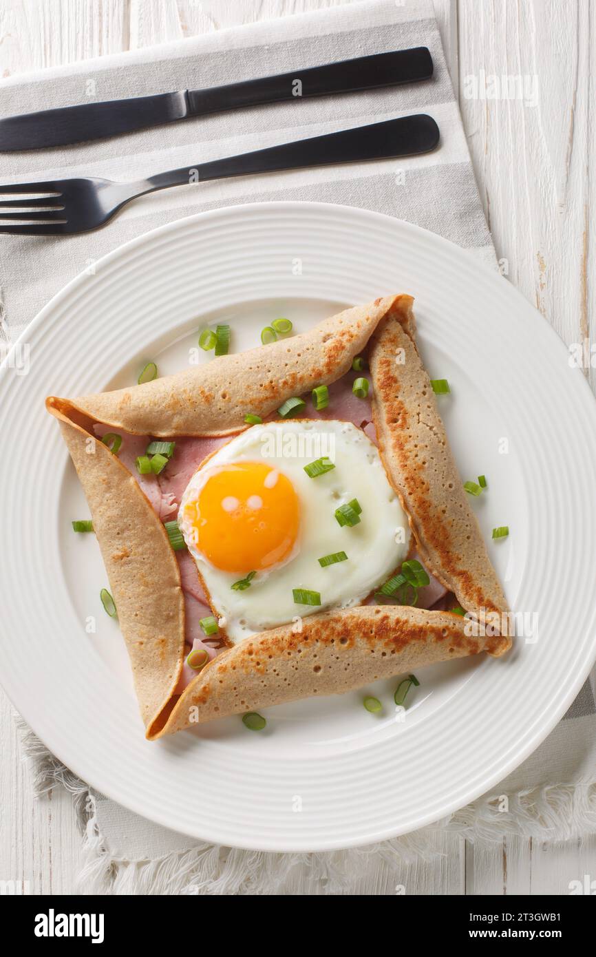 Les galettes de sarrasin avec œuf, jambon et fromage font un brunch incroyablement satisfaisant avec leur saveur savoureuse et noisette closeup sur l'assiette sur la table Banque D'Images