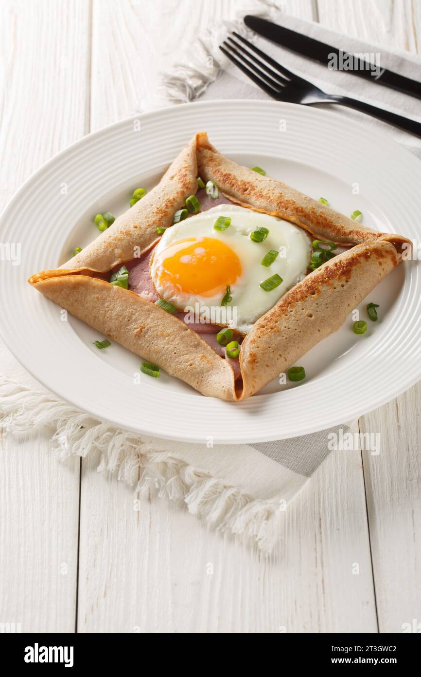 Les galettes de sarrasin avec œuf, jambon et fromage font un brunch incroyablement satisfaisant avec leur saveur savoureuse et noisette closeup sur l'assiette sur la table Banque D'Images