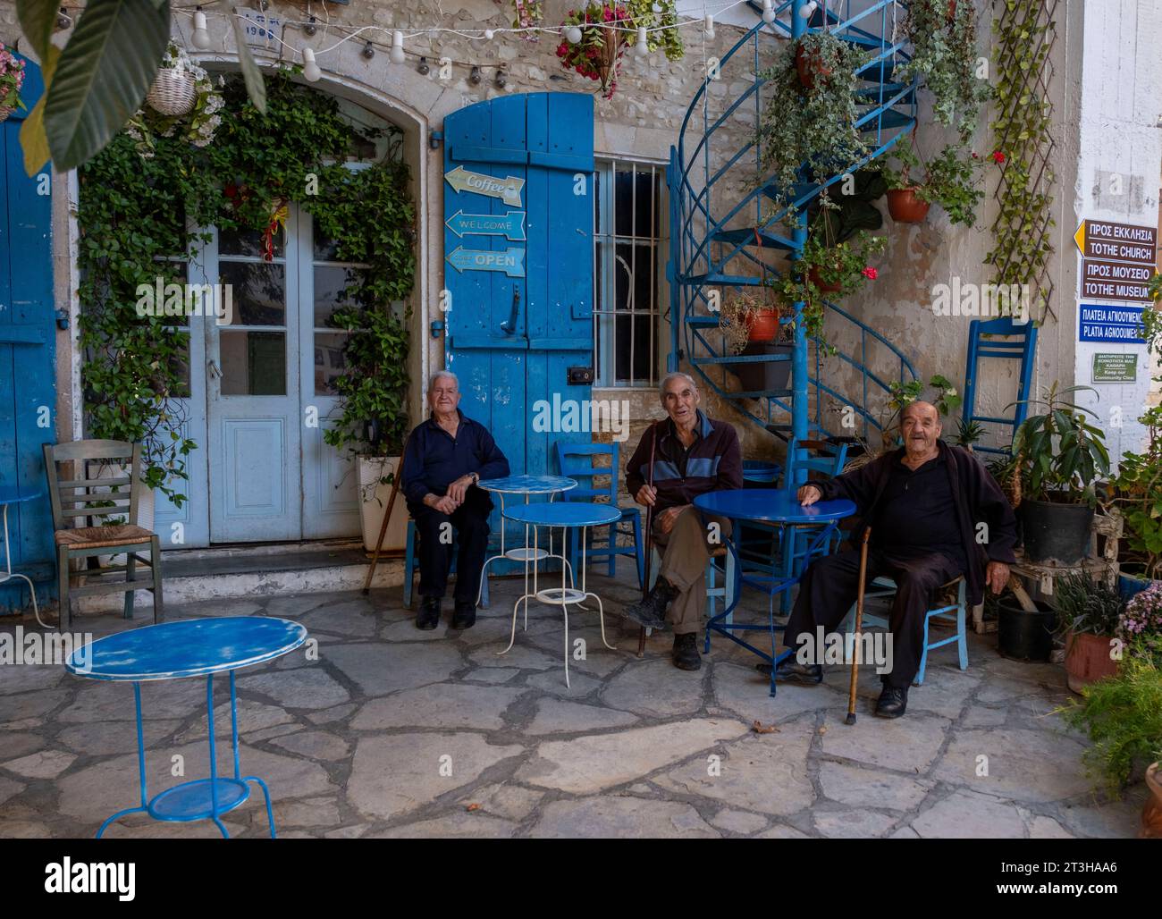 Des hommes âgés discutent devant le café historique Plateia (la place) dans le village de Vouni, district de Limassol, Chypre. Banque D'Images