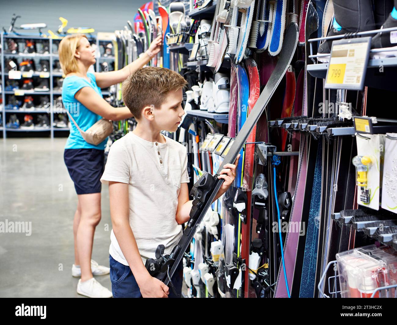 Garçon avec des skis alpins dans un magasin d'articles de sport Banque D'Images