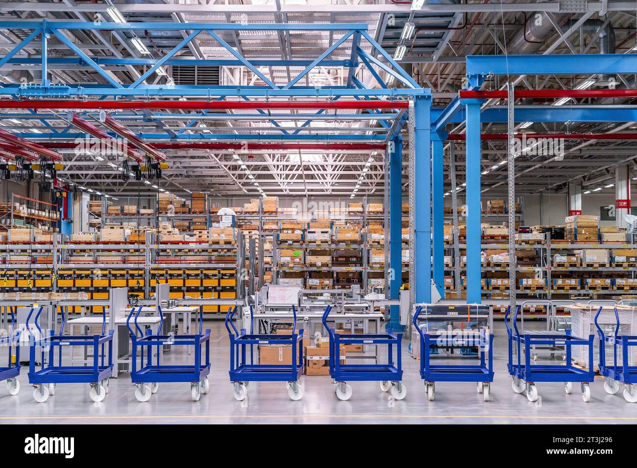 Vue de face de l'entrepôt d'usine de l'intérieur avec chariots de transport bleus Banque D'Images