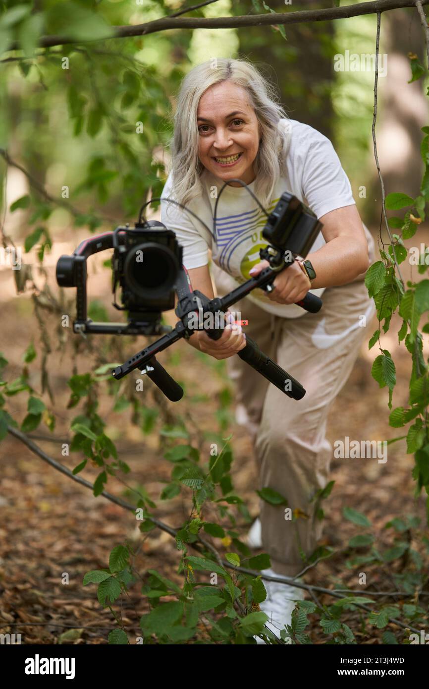 Femme vidéaste de nature avec caméra sur cardan dans la forêt Banque D'Images