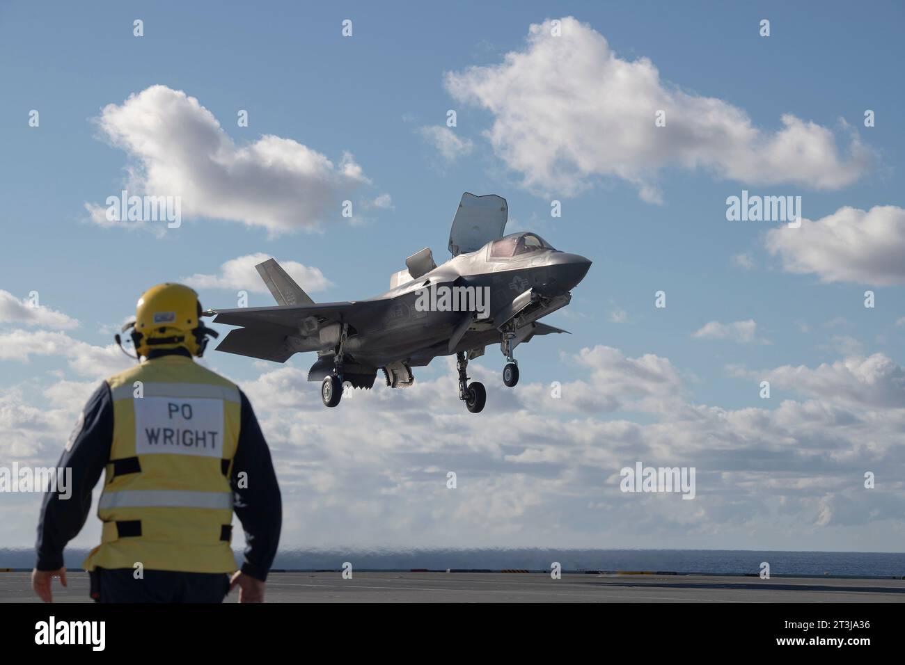 Patuxent River, États-Unis. 24 octobre 2023. Un pilote d'avion de la Royal Navy regarde un chasseur furtif F-35B Lightning II du corps des Marines américain effectuer un atterrissage vertical roulant embarqué sur le pont d'envol du porte-avions de classe Queen Elizabeth de la Royal Navy HMS Prince of Wales au cours des essais en vol de phase de développement 3, octobre 24, 2023 au large des côtes du Maryland, États-Unis. Crédit : Michael Jackson/États-Unis Navy photo/Alamy Live News Banque D'Images