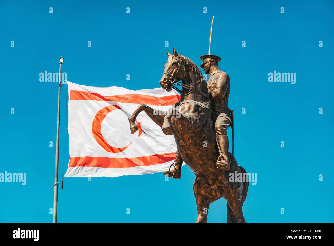 Les drapeaux de Türkiye et de Chypre du Nord flottent à côté d'une statue de Atatürk à cheval à un rond-point de la circulation dans le nord de Nicosie Banque D'Images