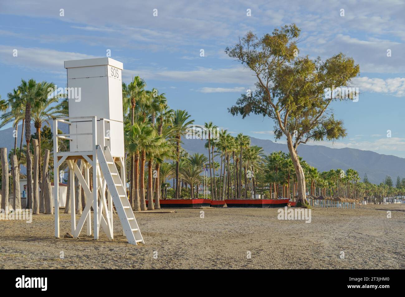 San pedro alcantara, malaga, espagne Maison de sauveteur sur la plage au lever du soleil avec des palmiers en arrière-plan et ciel bleu avec des nuages Banque D'Images