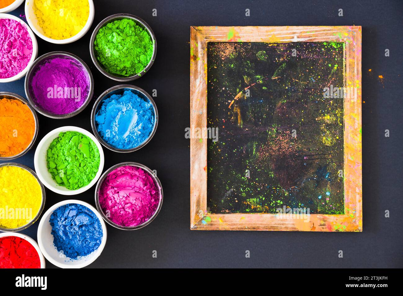 Bols de poudre de couleur Holi près du petit fond noir ardoise Banque D'Images