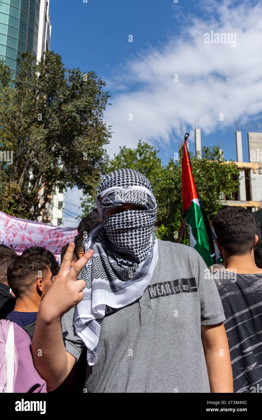 Refermez un jeune homme portant un foulard traditionnel palestinien (keffiyeh) et se couvrant le visage lors de la manifestation dans la ville de Sétif. Algérie. Banque D'Images