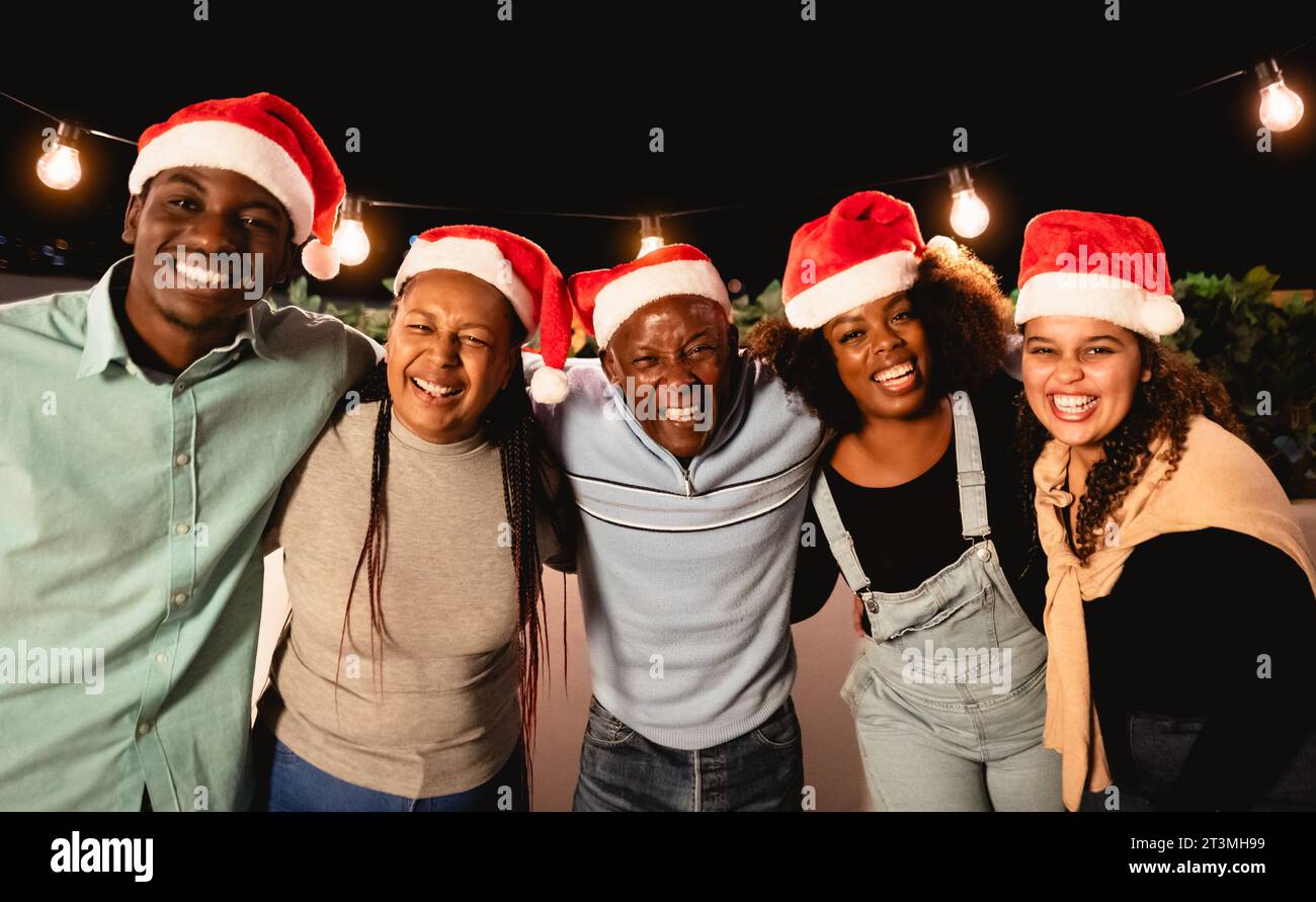 Famille africaine heureuse célébrant les vacances de Noël ensemble sur le toit de la maison Banque D'Images