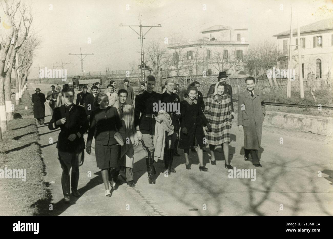 Groupe de jeunes hommes et femmes marchant dans la via Casilina à Torre Spaccata, Rome, Italie 1938 Banque D'Images