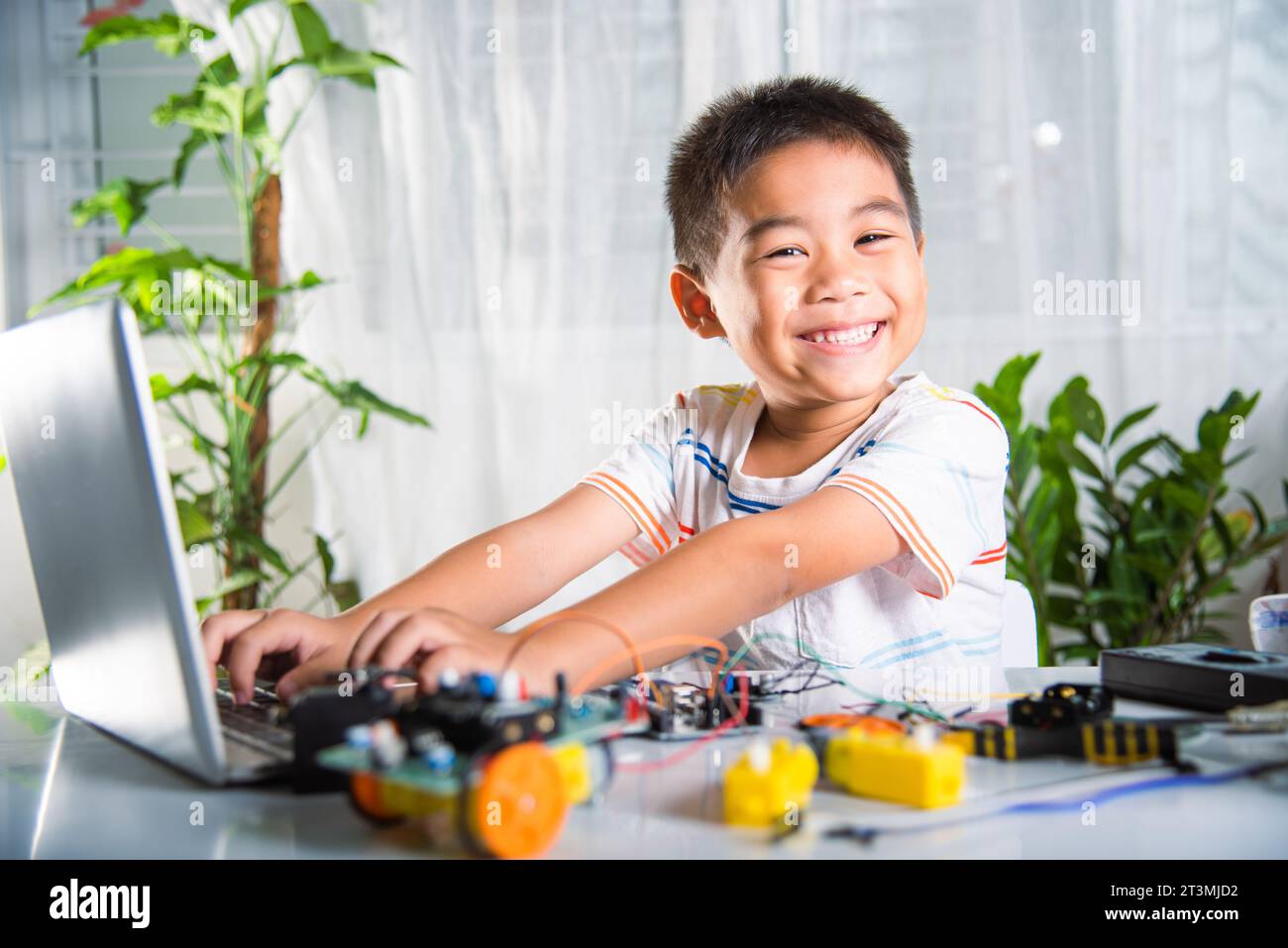 Un enfant asiatique apprend le codage et la programmation avec un ordinateur portable pour la voiture robot Arduino Banque D'Images