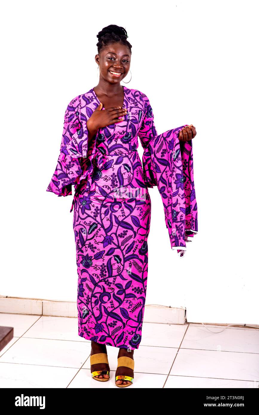 Portrait d'une belle jeune femme d'affaires africaine portant un lointain traditionnel tout en souriant à la caméra. Banque D'Images