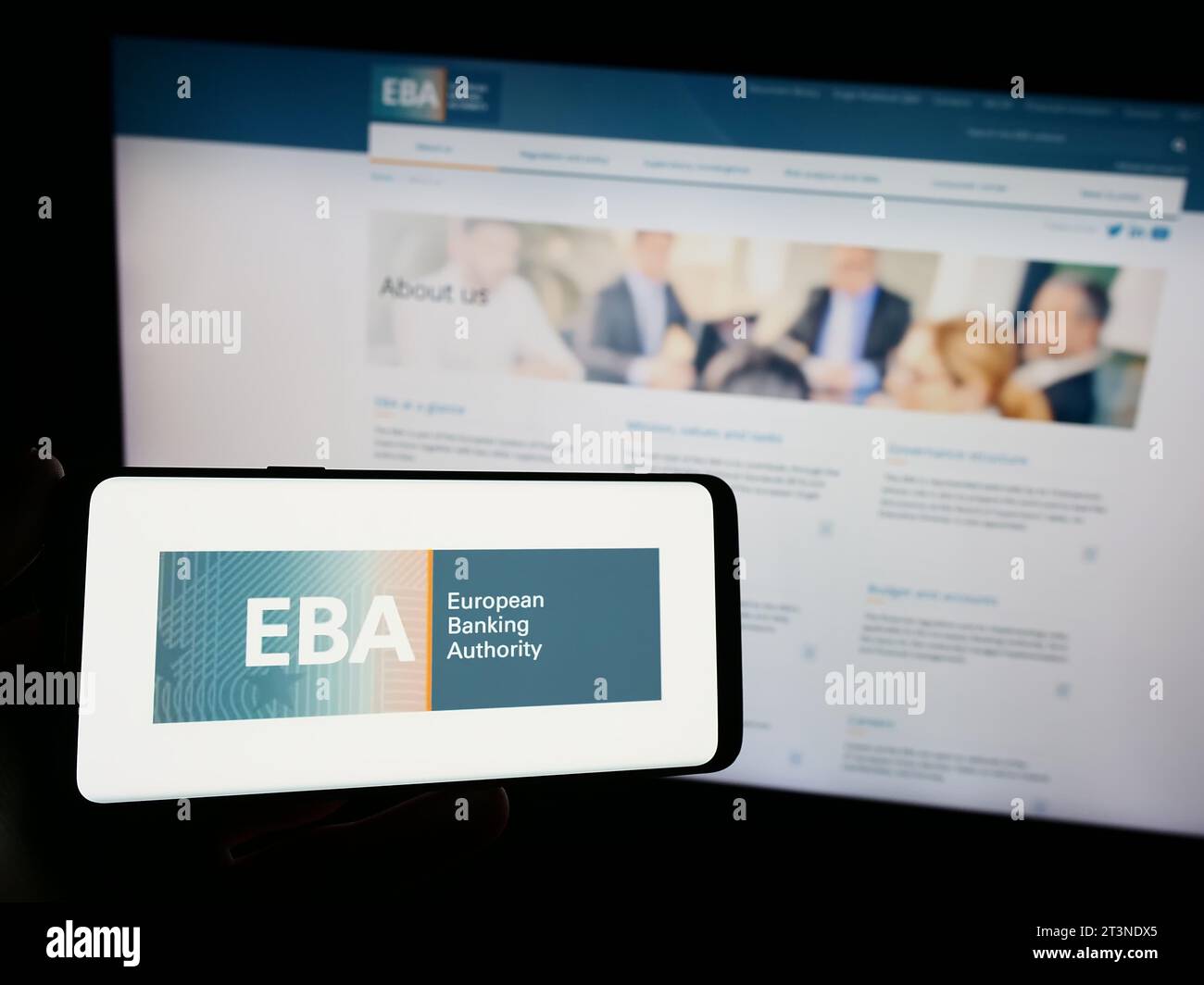 Titulaire d'un smartphone portant le logo de l'institution de l'UE Autorité bancaire européenne (ABE) devant le site Internet. Concentrez-vous sur l'affichage du téléphone. Banque D'Images