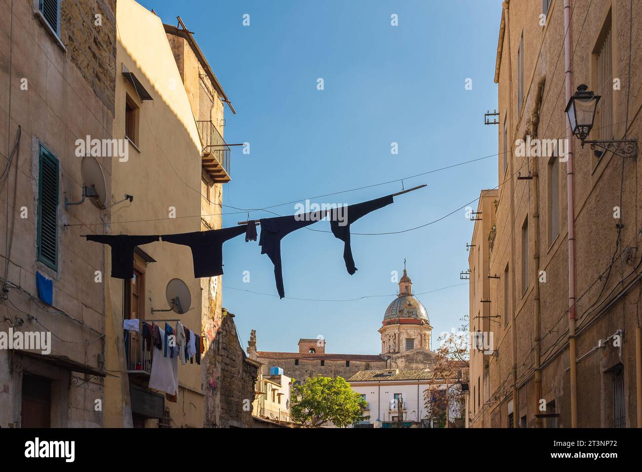 Palerme, Sicile, 2016. Séchage du linge sur une ligne à vêtements, avec l'église du Carmine Maggiore et son dôme carrelé de maiolica en arrière-plan Banque D'Images