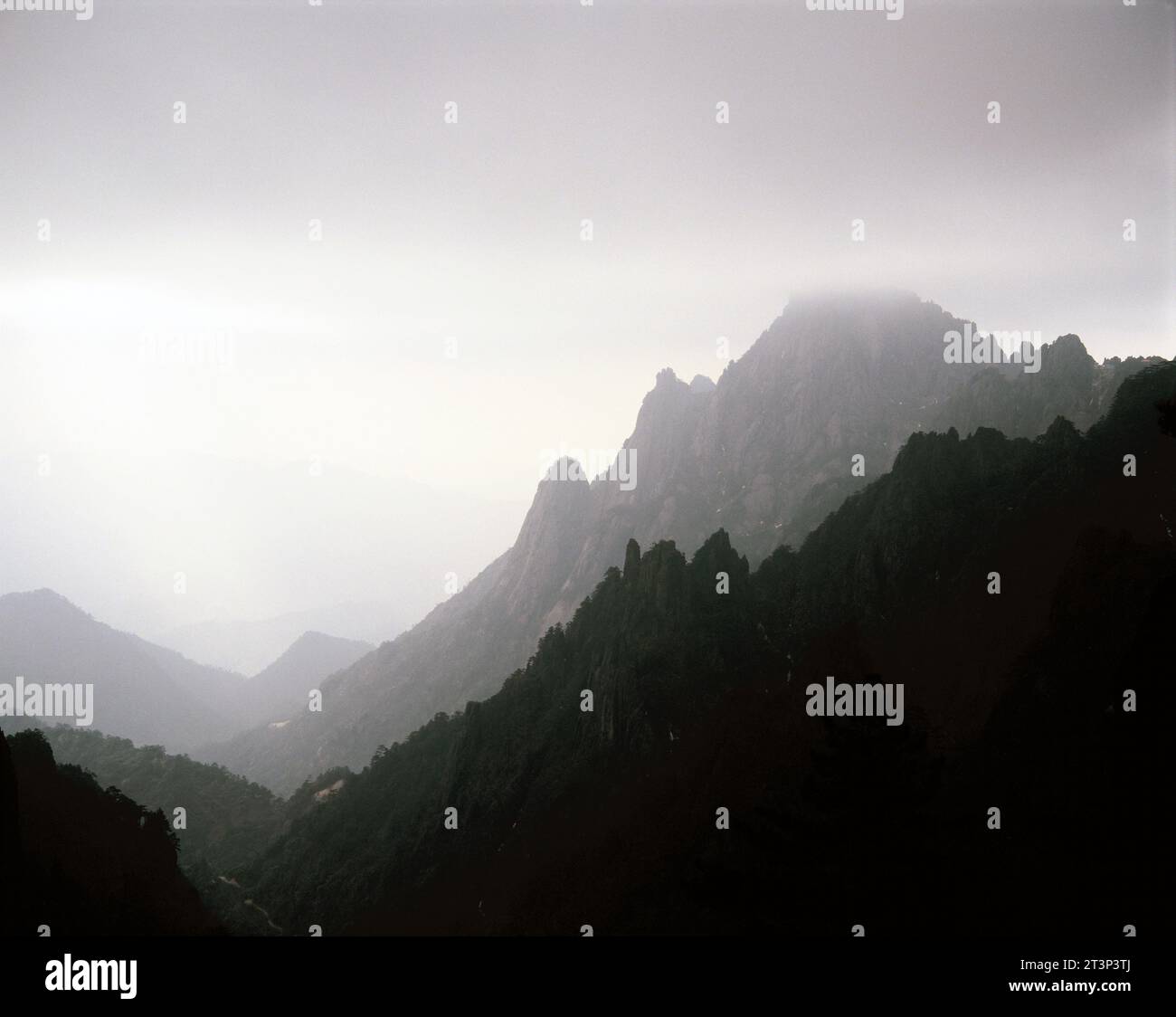 Chine. Anhui. Montagnes Huangshan avec ciel orageux. Banque D'Images