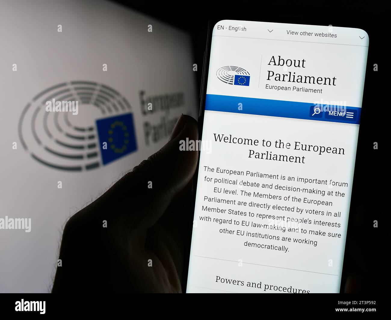 Personne détenant un téléphone portable avec la page web de l'organe législatif de l'UE Parlement européen (PE) devant le logo. Concentrez-vous sur le centre de l'écran du téléphone. Banque D'Images