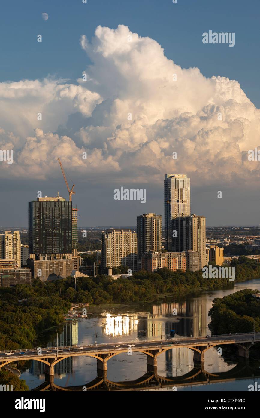 Vue sur Rainey Street District d'Austin, TX avec lune, cumulus nuages et Ladybird Lake. Banque D'Images