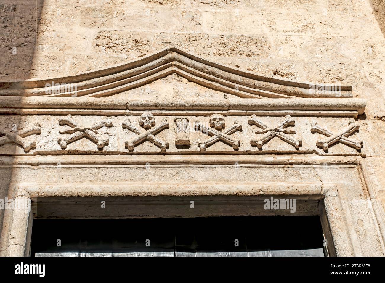 Sur la porte de l'église Chiesa Del Purgatorio (années 1700) in. Polignano a Mare, Italie, crâne et os croisés et un design en sablier. Banque D'Images