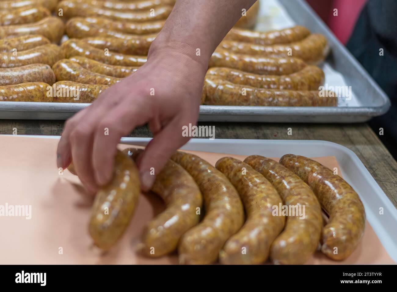 Image isolée en gros plan haute résolution du processus de création de saucisses crues non cuites faites à la main dans une boucherie boutique- USA Banque D'Images