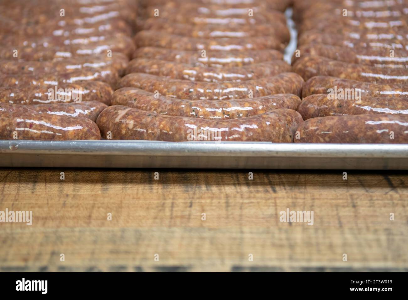 Image isolée en gros plan haute résolution du processus de création de saucisses crues non cuites faites à la main dans une boucherie boutique- USA Banque D'Images
