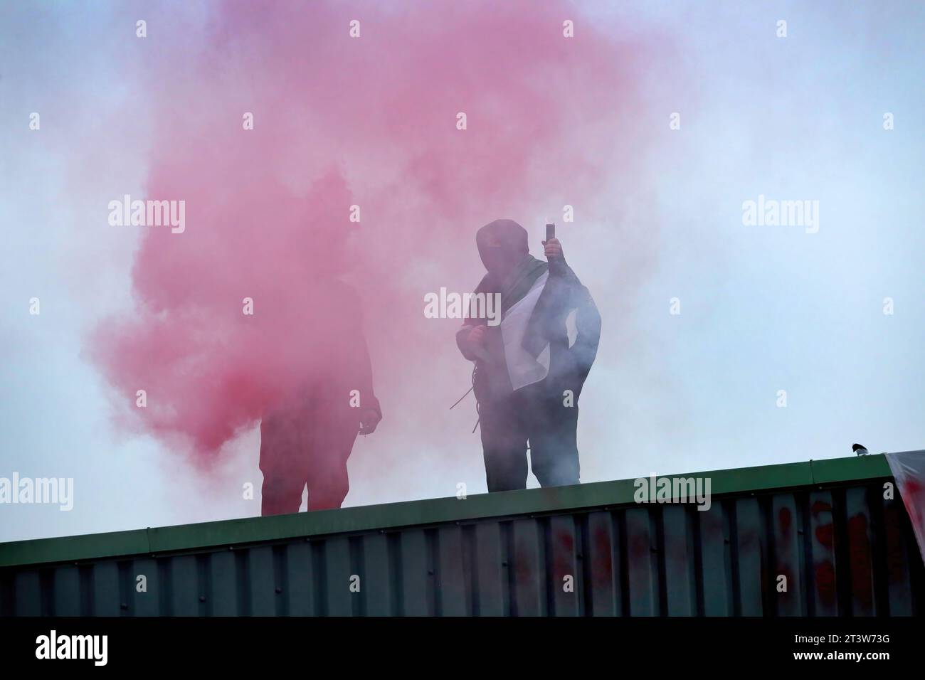 Deux militants de Palestine action brandissent des fusées éclairantes après avoir occupé le toit de Howmet Aerospace. Des militants de Palestine action ont annoncé que les entreprises vendant des armes aux Forces de défense israéliennes et à leurs entreprises partenaires seront ciblées par une action directe. Ces actions visent à mettre en lumière le sort des Palestiniens à Gaza et en Cisjordanie, mais aussi à perturber le secteur manufacturier de ces entreprises. Palestine action a déclaré qu'ils ne cesseront pas leurs actions tant que l'industrie de l'armement ne cessera pas de soutenir Israël. Banque D'Images