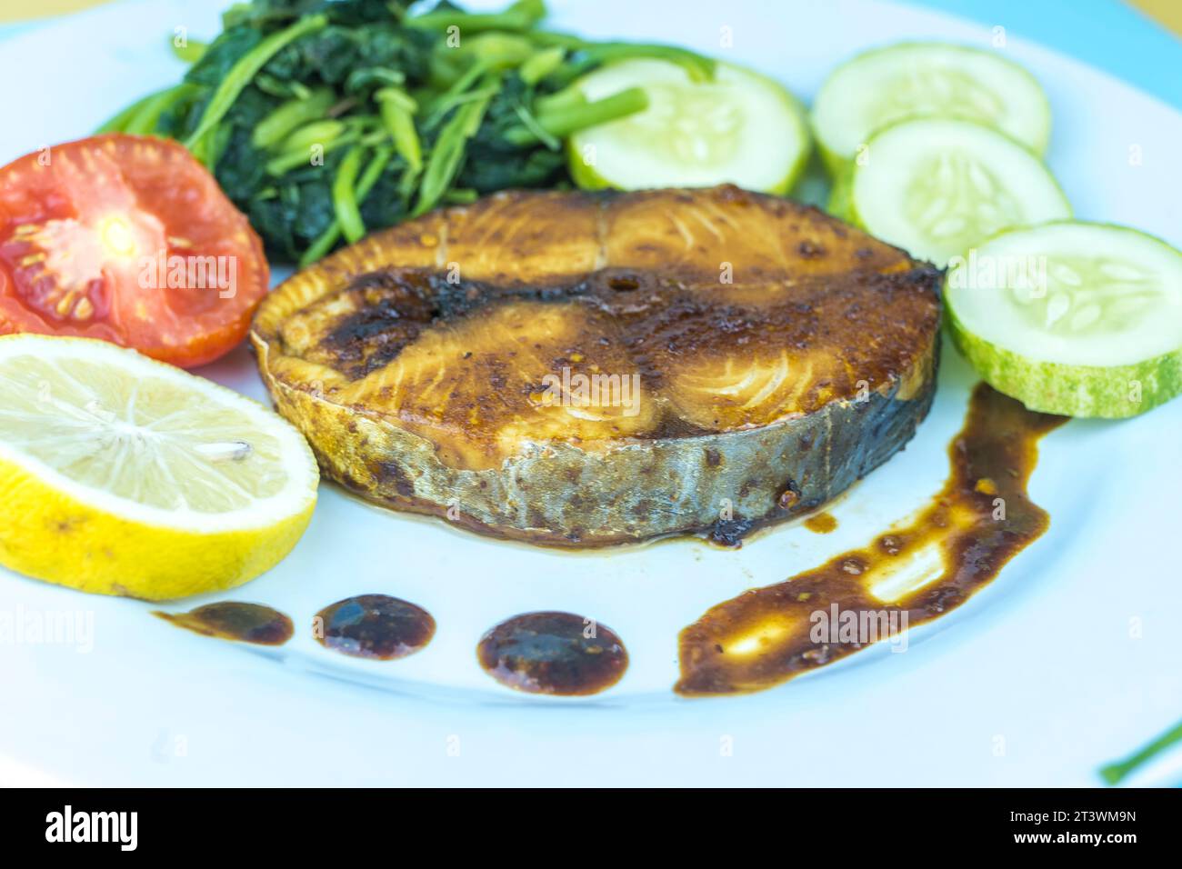 Poisson-pêcheur grillé sur une assiette, à la peau croustillante et à la chair blanche floconneuse servi avec des légumes mélangés Banque D'Images