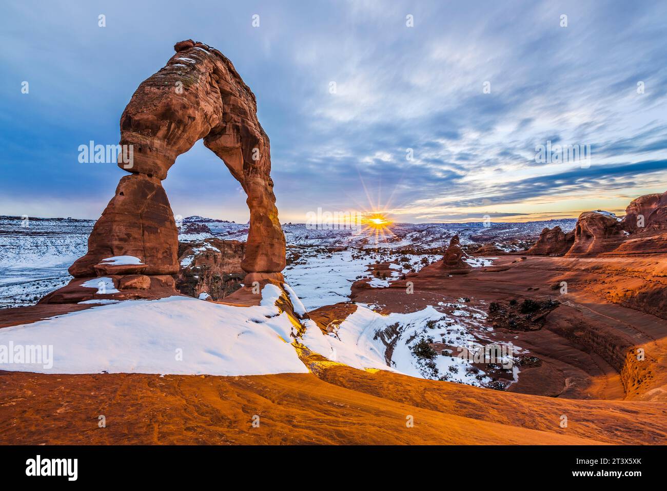 Paysage d'une grande arche rocheuse naturelle en hiver au coucher du soleil. Banque D'Images