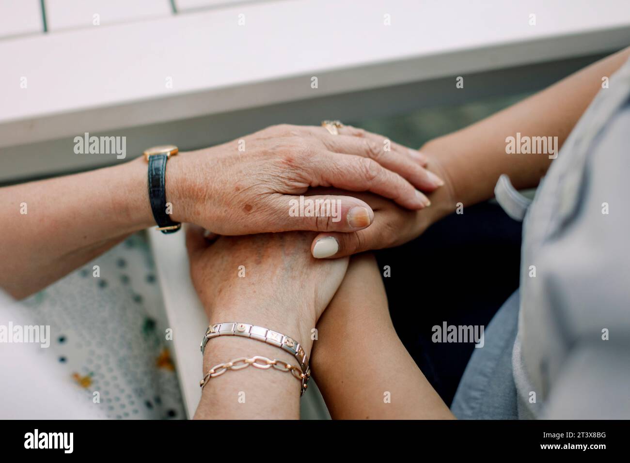 Section médiane d'un homme âgé et d'une infirmière tenant la main dans une maison de retraite Banque D'Images