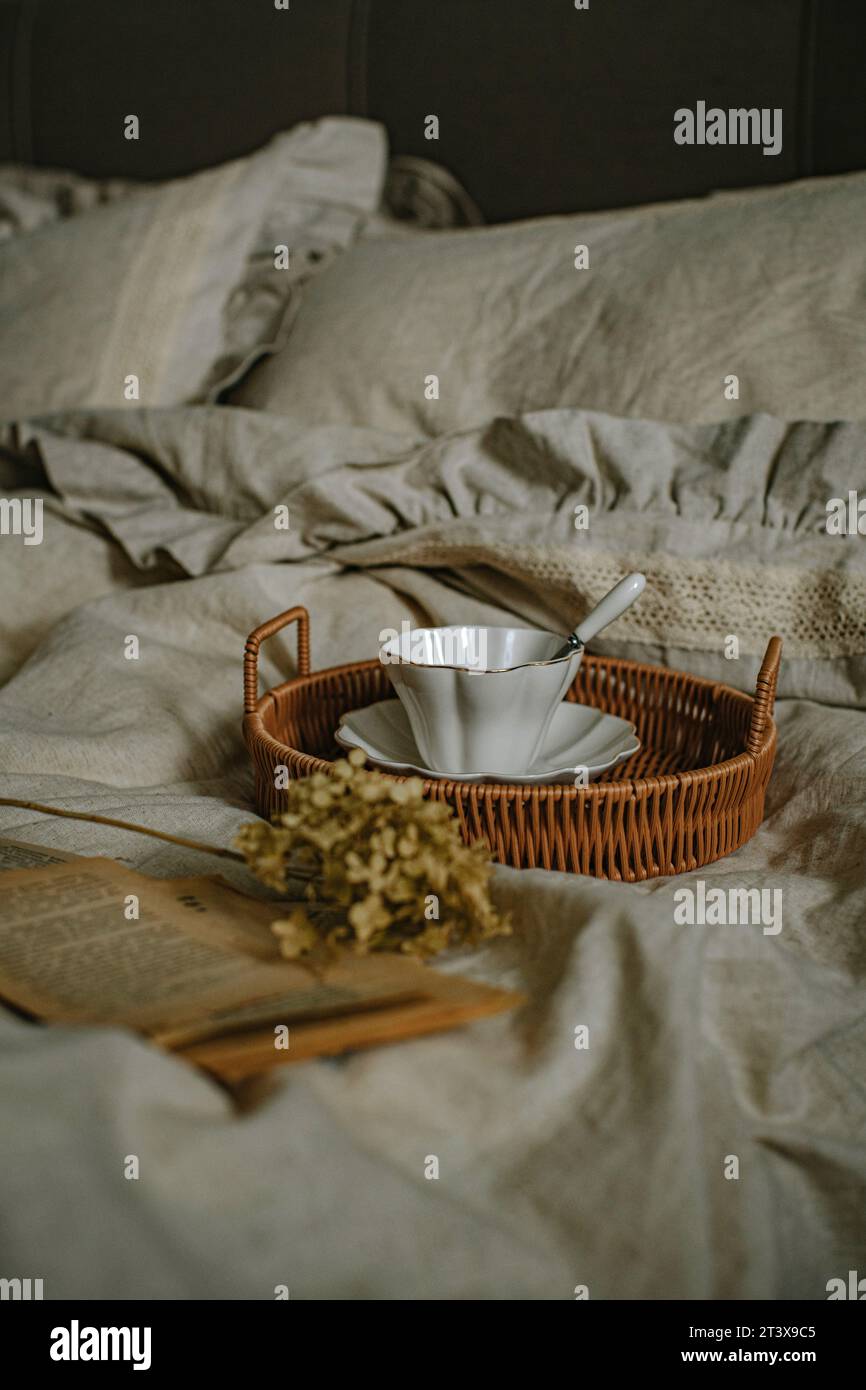 Beaux draps de lit en lin et une tasse blanche en céramique Banque D'Images