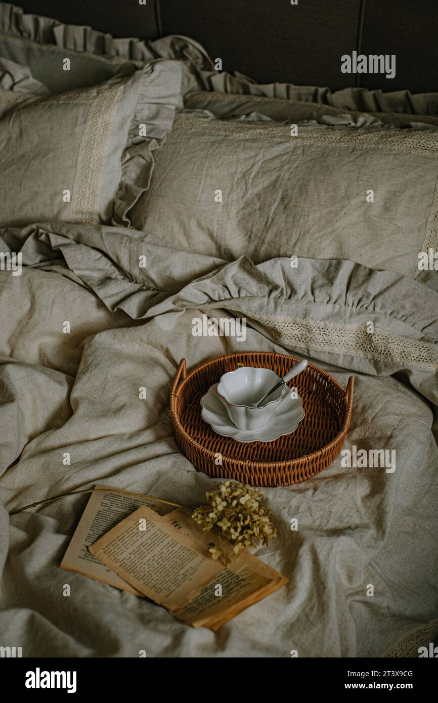 Beaux draps de lit en lin et une tasse blanche en céramique Banque D'Images