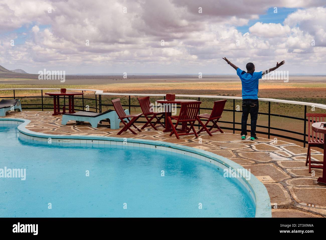 Un homme près d'une piscine à un point de vue panoramique dans un Lodge au parc national de Tsavo East, au Kenya Banque D'Images