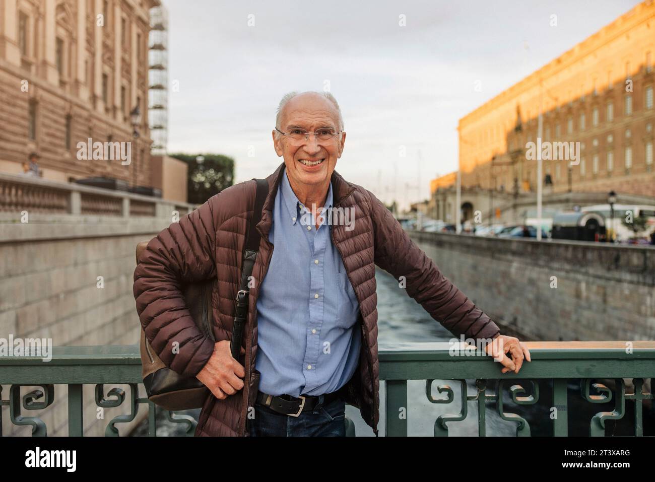 Portrait d'un homme âgé heureux appuyé sur la balustrade au-dessus du canal Banque D'Images