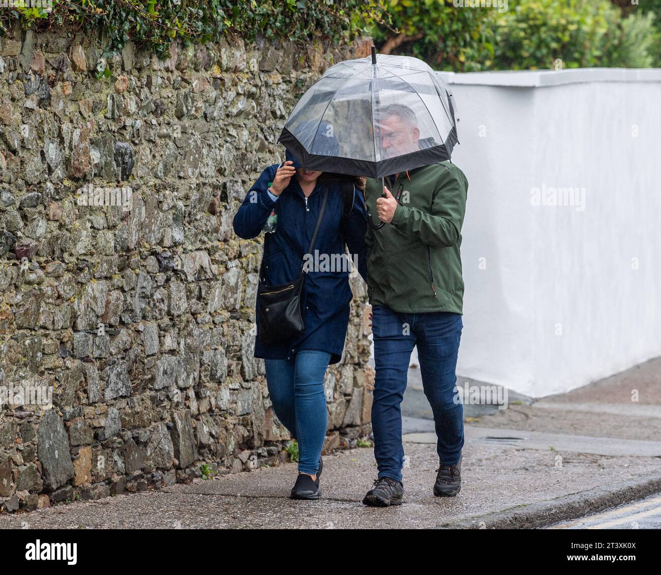 Les gens luttant contre les vents violents et les fortes pluies sous un avertissement météorologique met Éireann à Tramore, Co. Waterford, Irlande. Banque D'Images