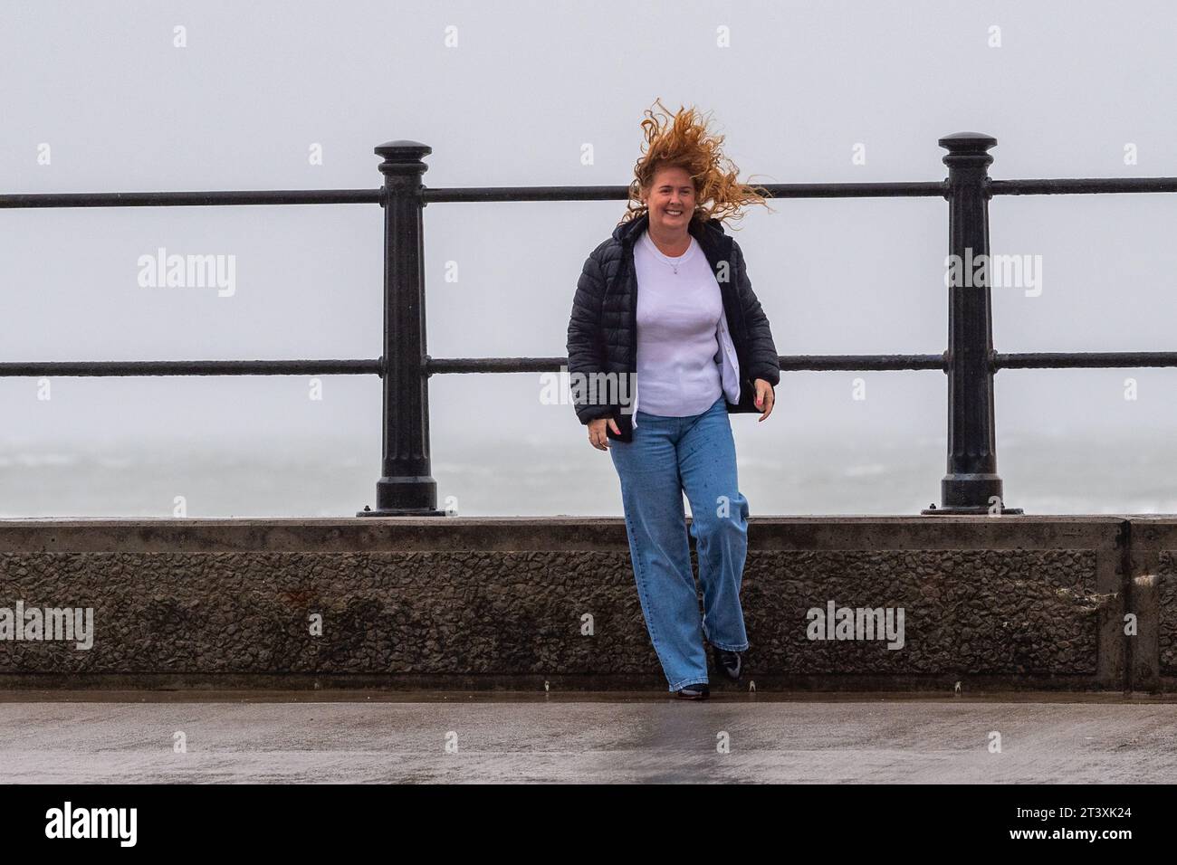 Les gens luttant contre les vents violents et les fortes pluies sous un avertissement météorologique met Éireann à Tramore, Co. Waterford, Irlande. Banque D'Images