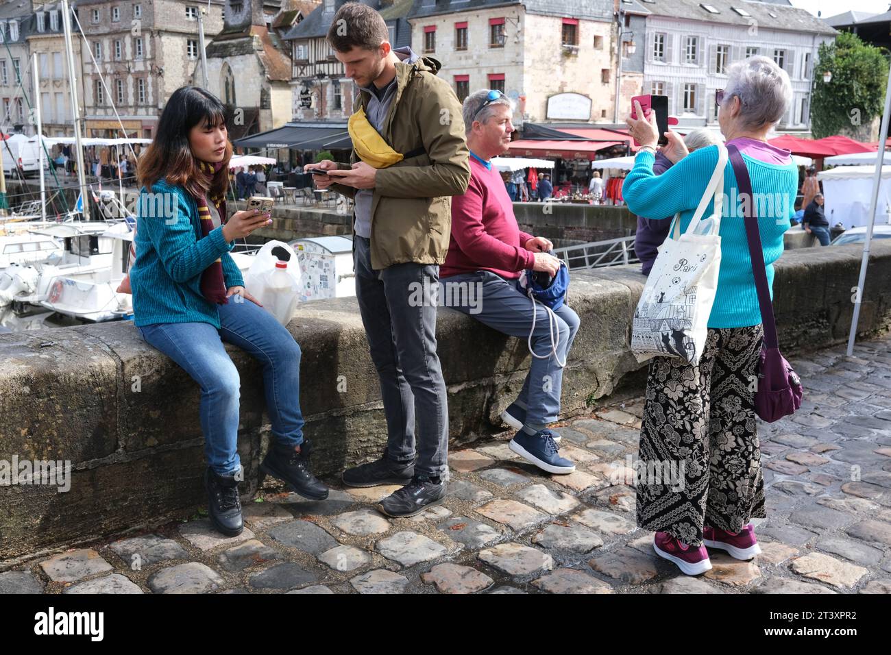 Personnes touristes utilisant des appareils de téléphonie mobile France, Français, Normandie, 2023 Banque D'Images