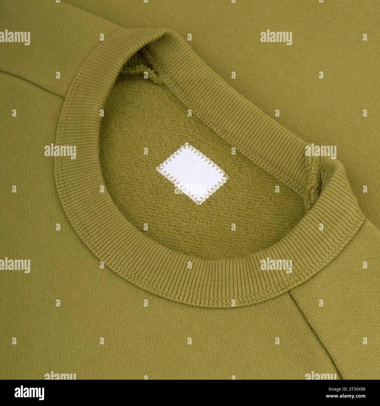 Col ras du cou d'un sweat-shirt vert étiquette modèle fond gros plan Banque D'Images