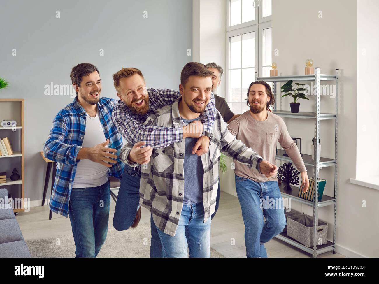 Groupe d'hommes heureux joyeux excités embrassant et félicitant l'ami pour le grand succès Banque D'Images