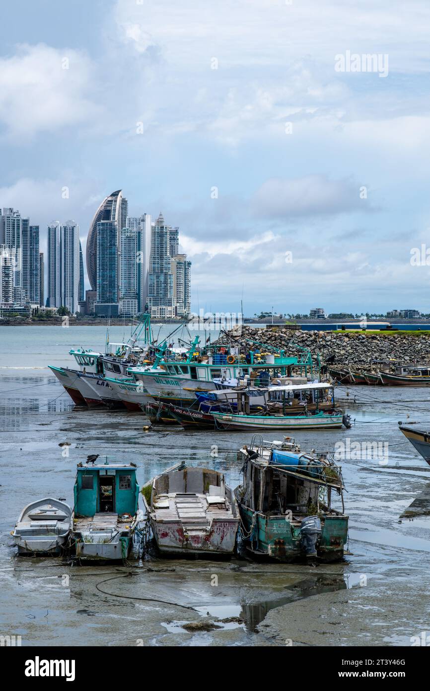 Une vue de la vieille ville de Panama à travers la baie de Panama à Panama City, avec de vieux bateaux de pêche au premier plan Banque D'Images