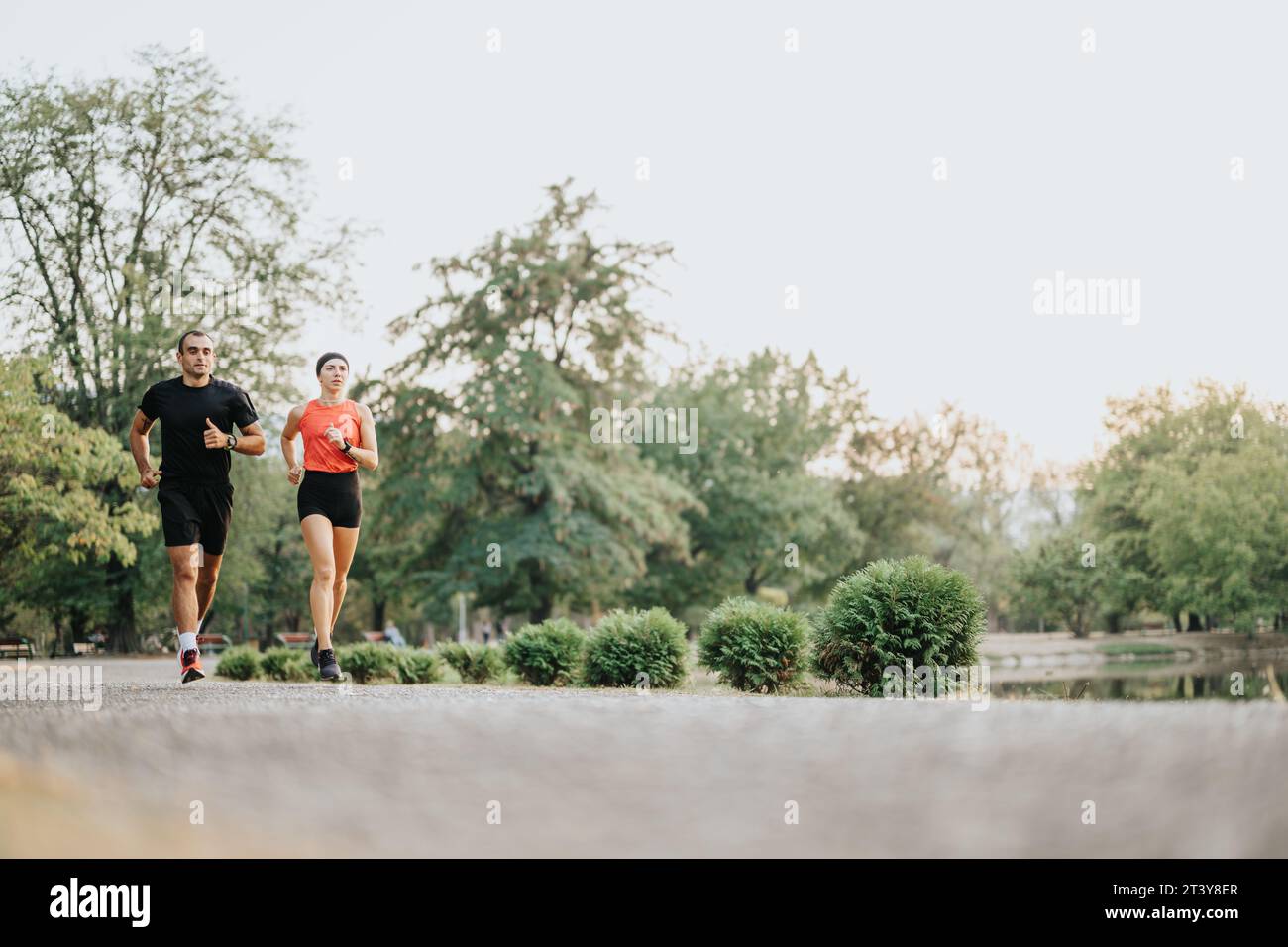 Après-midi Cardio : couple actif profitant de l'entraînement en plein air dans le parc Banque D'Images