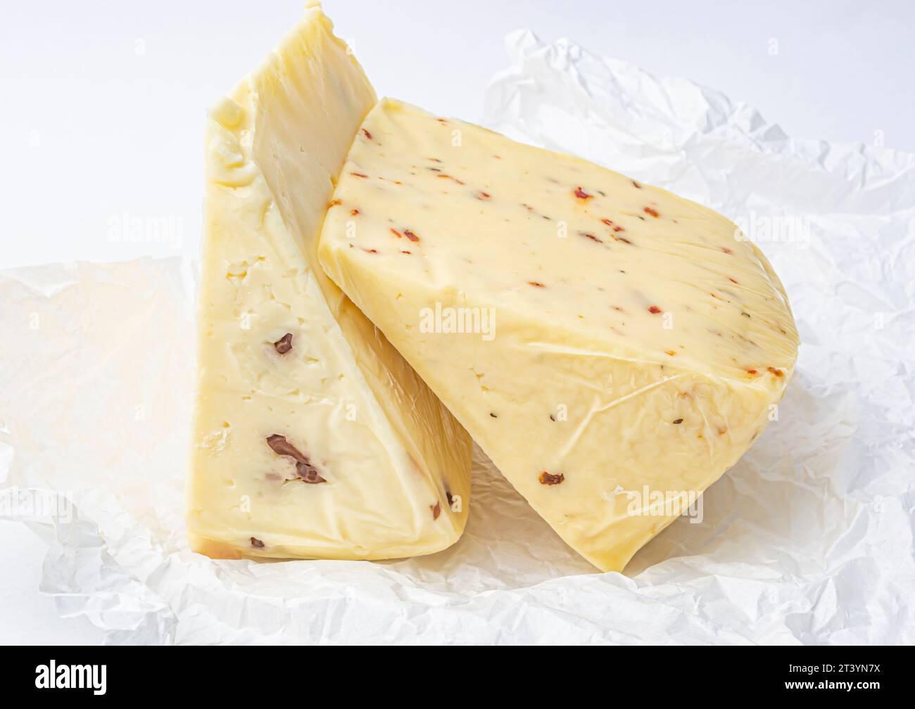 morceau de fromage avec noix et paprika sur papier menthe blanche gros plan Banque D'Images