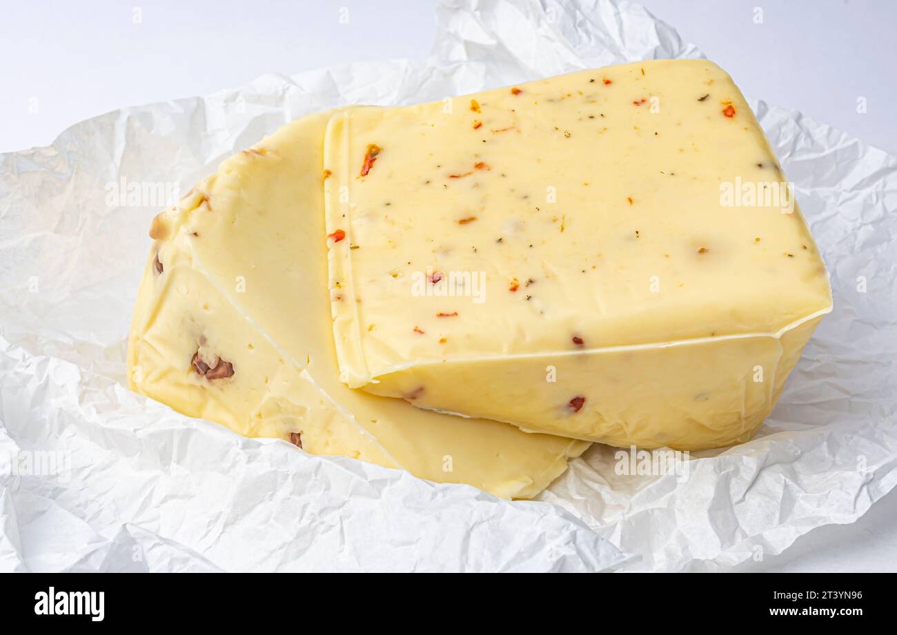 morceau de fromage avec noix et paprika sur papier menthe blanche gros plan Banque D'Images