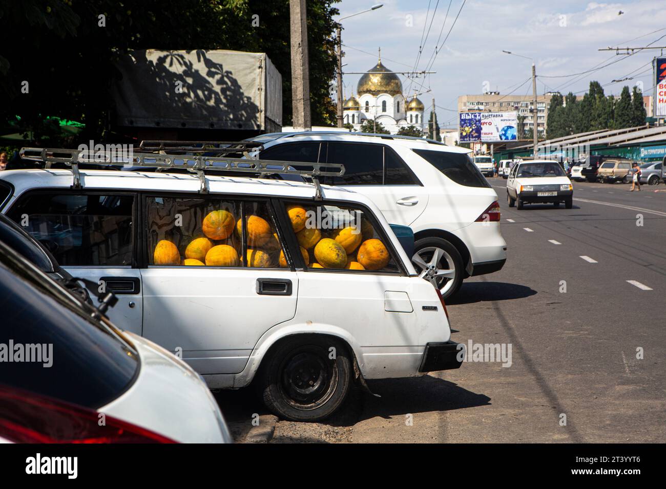Voitures garées près du marché alimentaire à Odessa, Ukraine. Old Lada entièrement chargée de melons, donc les roues du véhicule s'affaissent, c'est août et les agriculteurs se dépêchent Banque D'Images