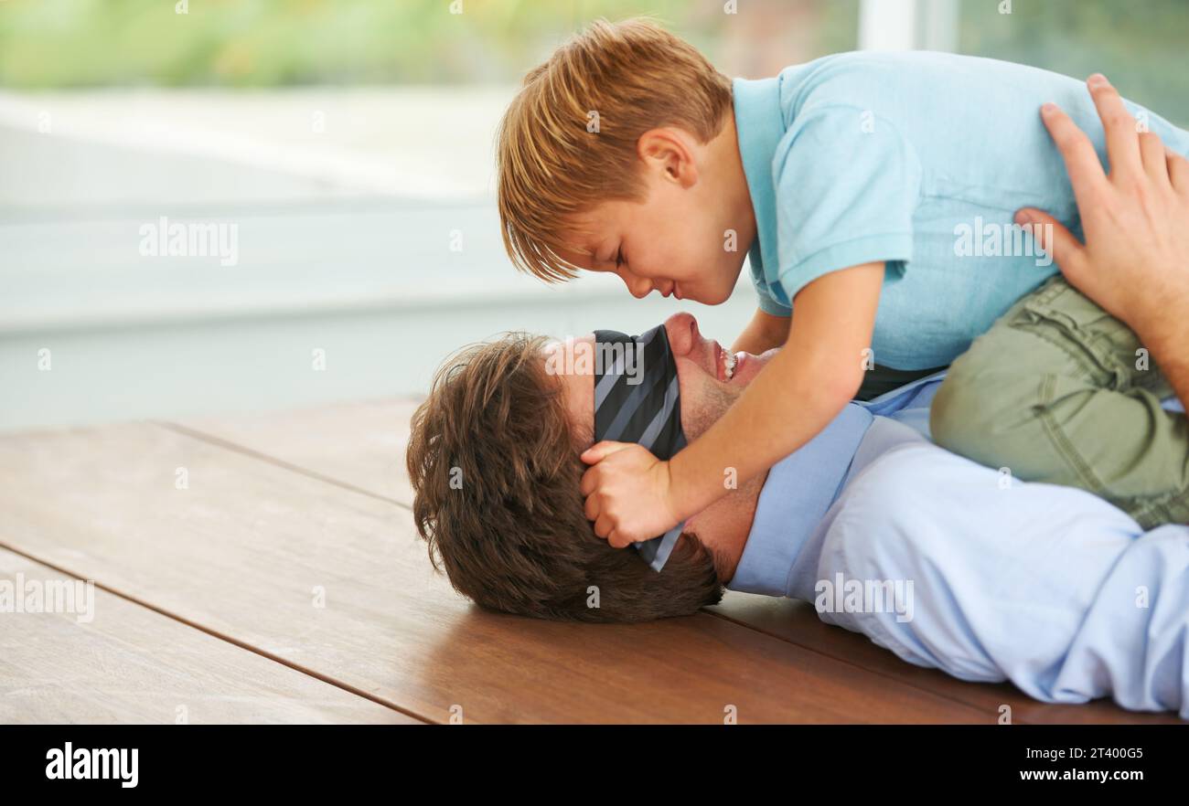 Homme, bandeau et jeu pour jouer avec l'enfant, plancher de salon ou heureux ensemble par le soutien de l'homme d'affaires. Papa, garçon et sourire dans la maison familiale, fantaisie Banque D'Images