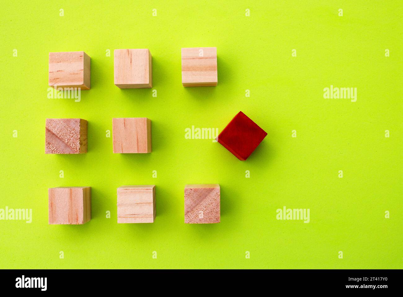 Cube en bois rouge qui diffère du reste des cubes alignés Banque D'Images