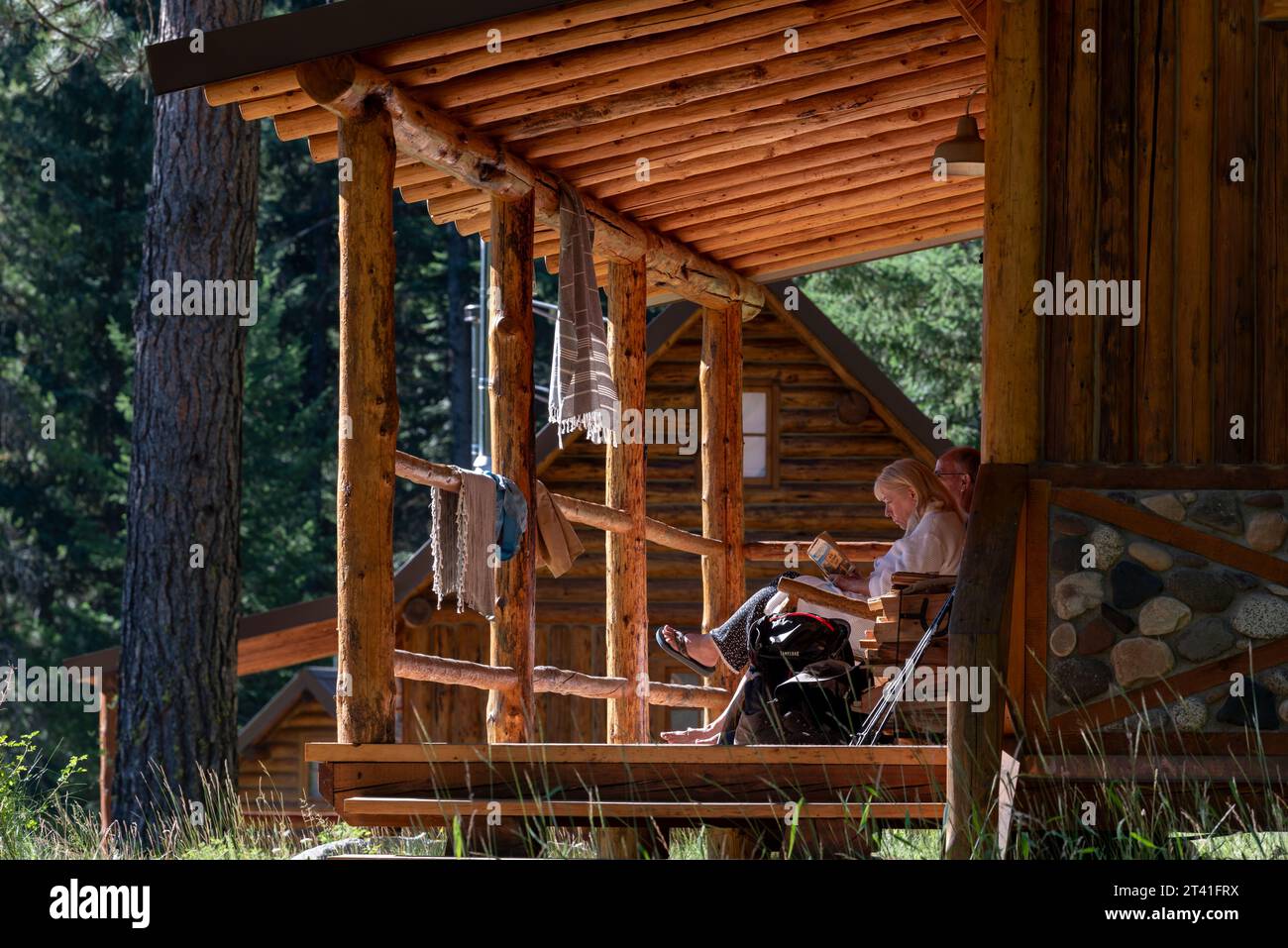 Couple de détente sur le porche d'une cabine au Minam River Lodge, Oregon. Banque D'Images